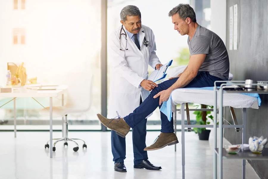 Patient consulting with specialist to determine GAE candidacy for knee pain