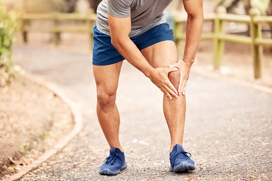 Man running outdoors with knee pain before GAE