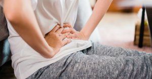 asian woman having painful on her stomachache or Pelvic pain; blog: Pelvic Congestion Syndrome Symptoms and Treatments